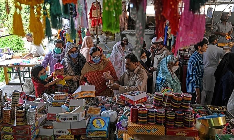 Customers shop for bangles at a market in Islamabad on May 9. — AFP